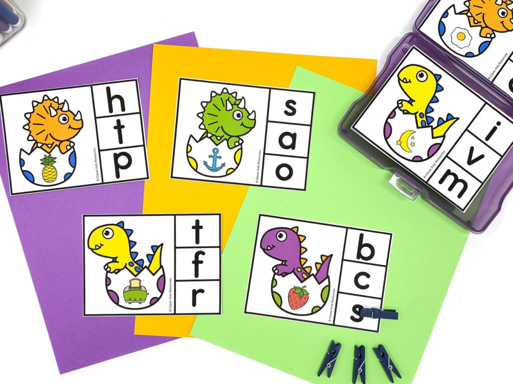 Set of dinosaur-themed beginning sounds clip cards on colorful paper, designed for kindergarten literacy centers with picture prompts and multiple choice letters.